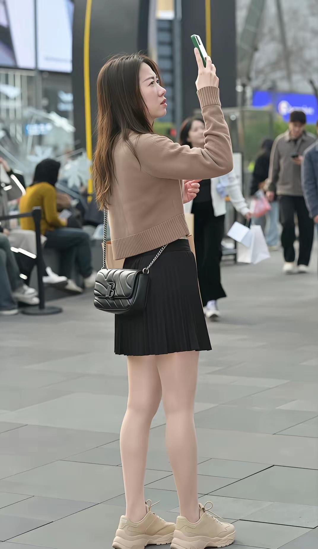 都市时尚少女，棕色毛衣搭配黑色短裙，轻松自拍，享受都市生活！