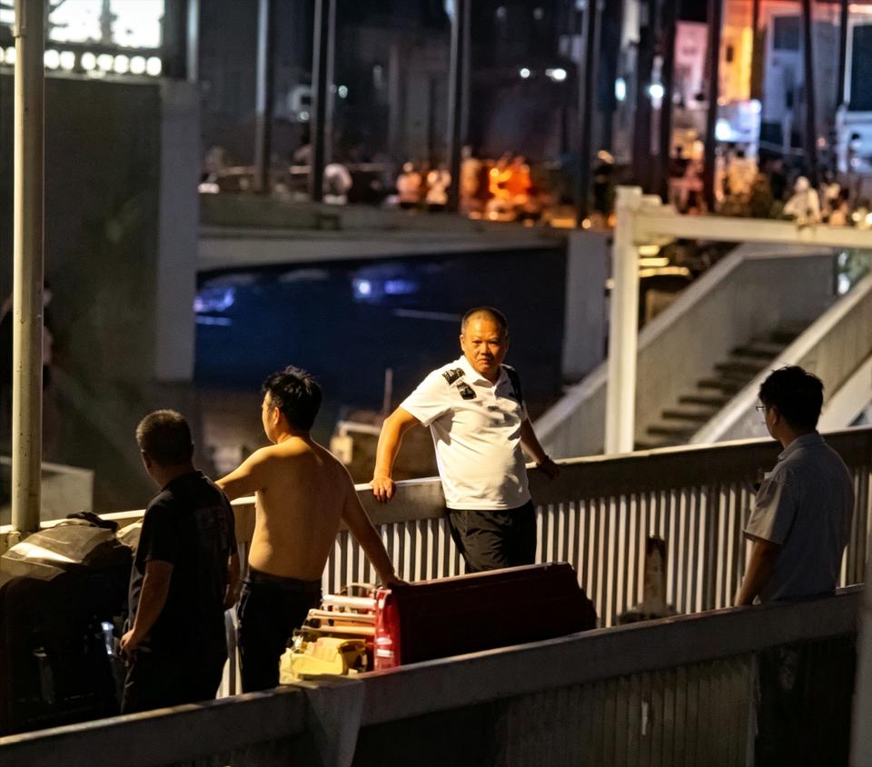 据网友爆料称，9日晚在湖北武汉武昌区司门口附近一天桥上，几名穿着制服的城管人员对