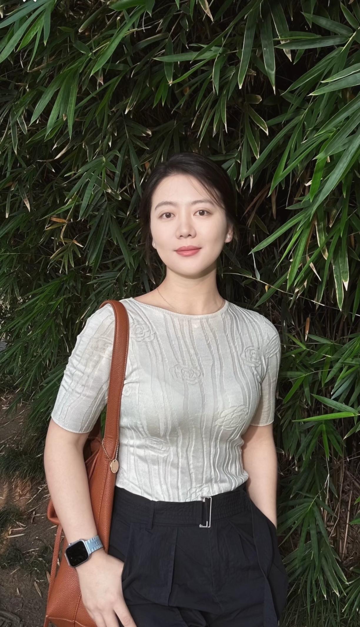 知性，成熟的姐姐在绿叶前留影。