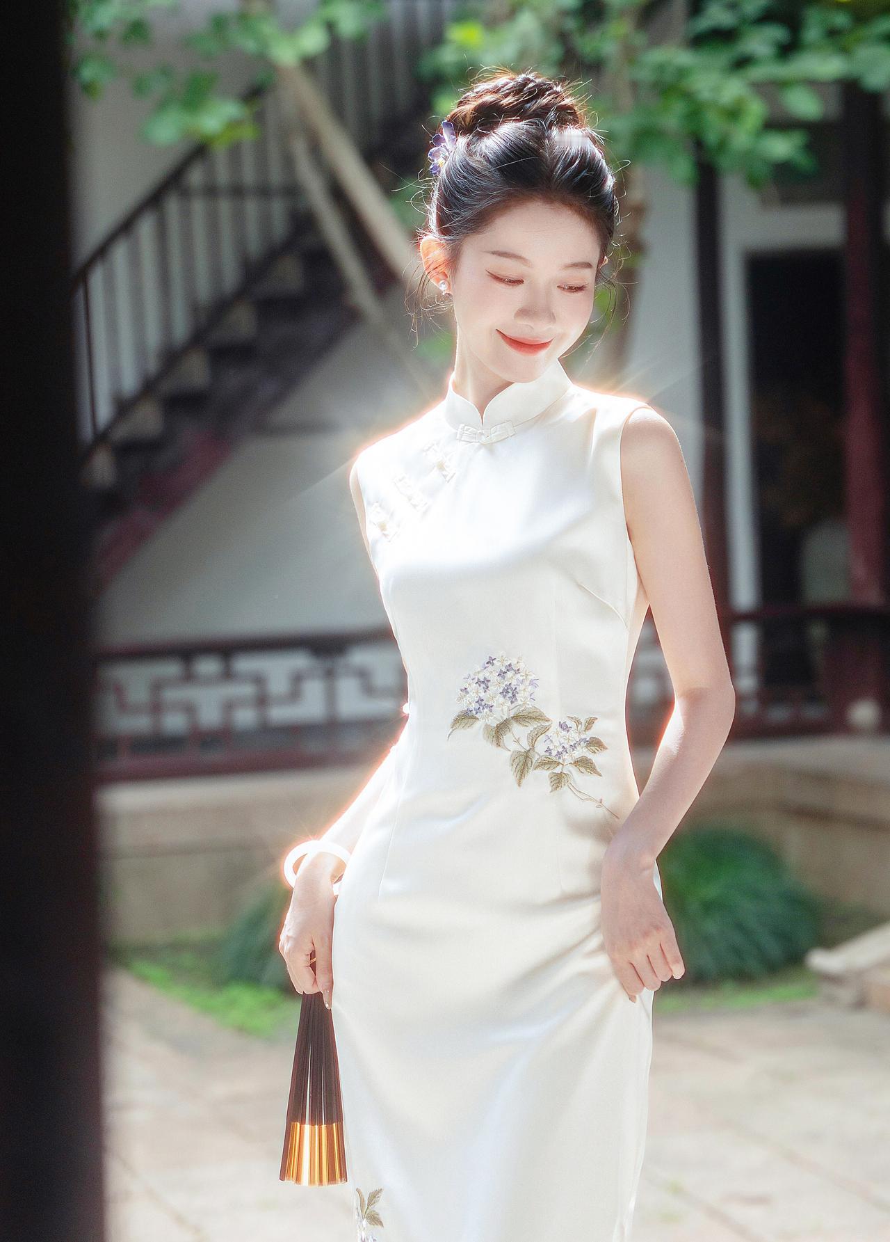 晴光一缕落襟边，白缎裁云绣紫妍。团扇轻摇庭榭里，江南风韵入眉弯。