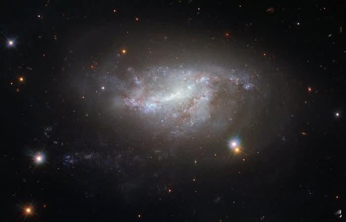 在一场令人叹为观止的宇宙芭蕾中，雄伟的螺旋星系NGC5917正与它的邻近伴侣M