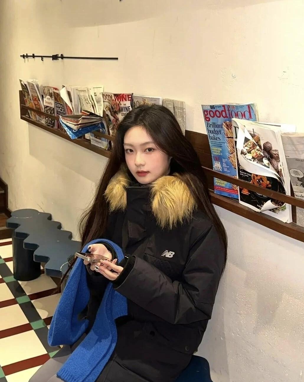 🧥裹着带毛领的黑色羽绒服，抱着宝蓝色围巾，在堆满杂志的小店角落坐一会儿。暖黄