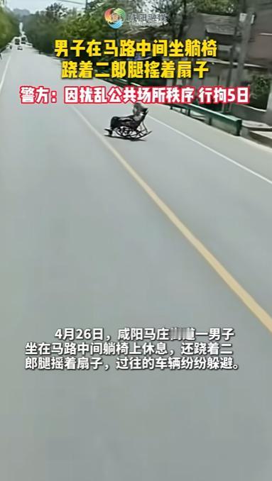 陕西，一男子直接坐在马路中间躺椅上休息，甚至还翘着二郎腿扇扇子，完全不把旁边躲避