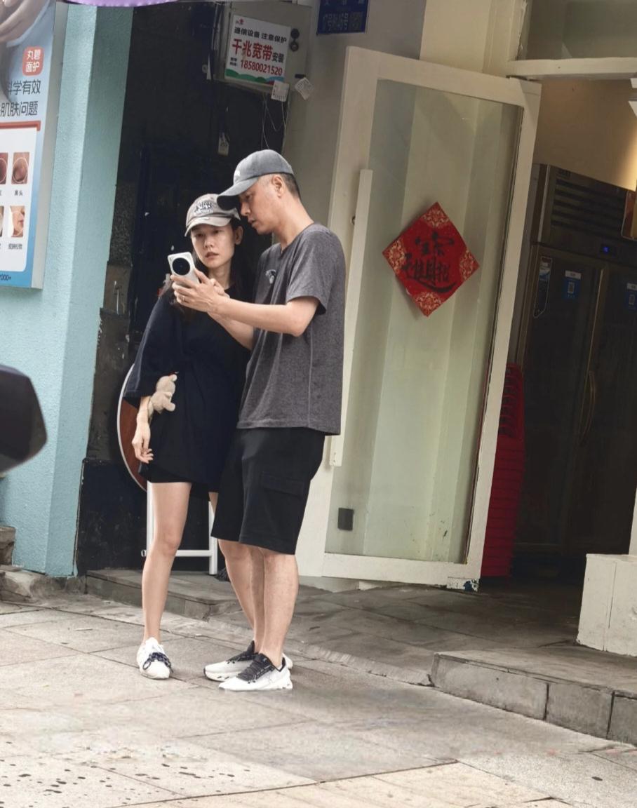 47岁任重和老婆孙骁骁在重庆街边被偶遇，两人刚从一家餐馆出来，站在店门口看手机，