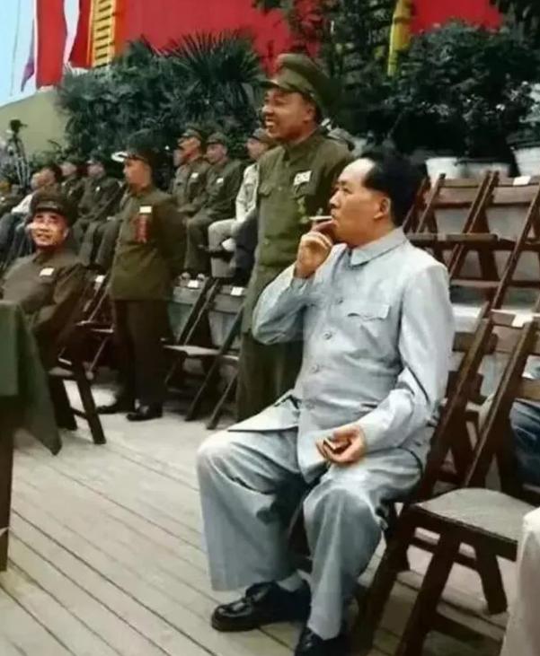 毛主席观看全国第一届军运会。他端坐在木椅上，也不靠背，挺起腰杆，坐姿挺拔。毛泽东