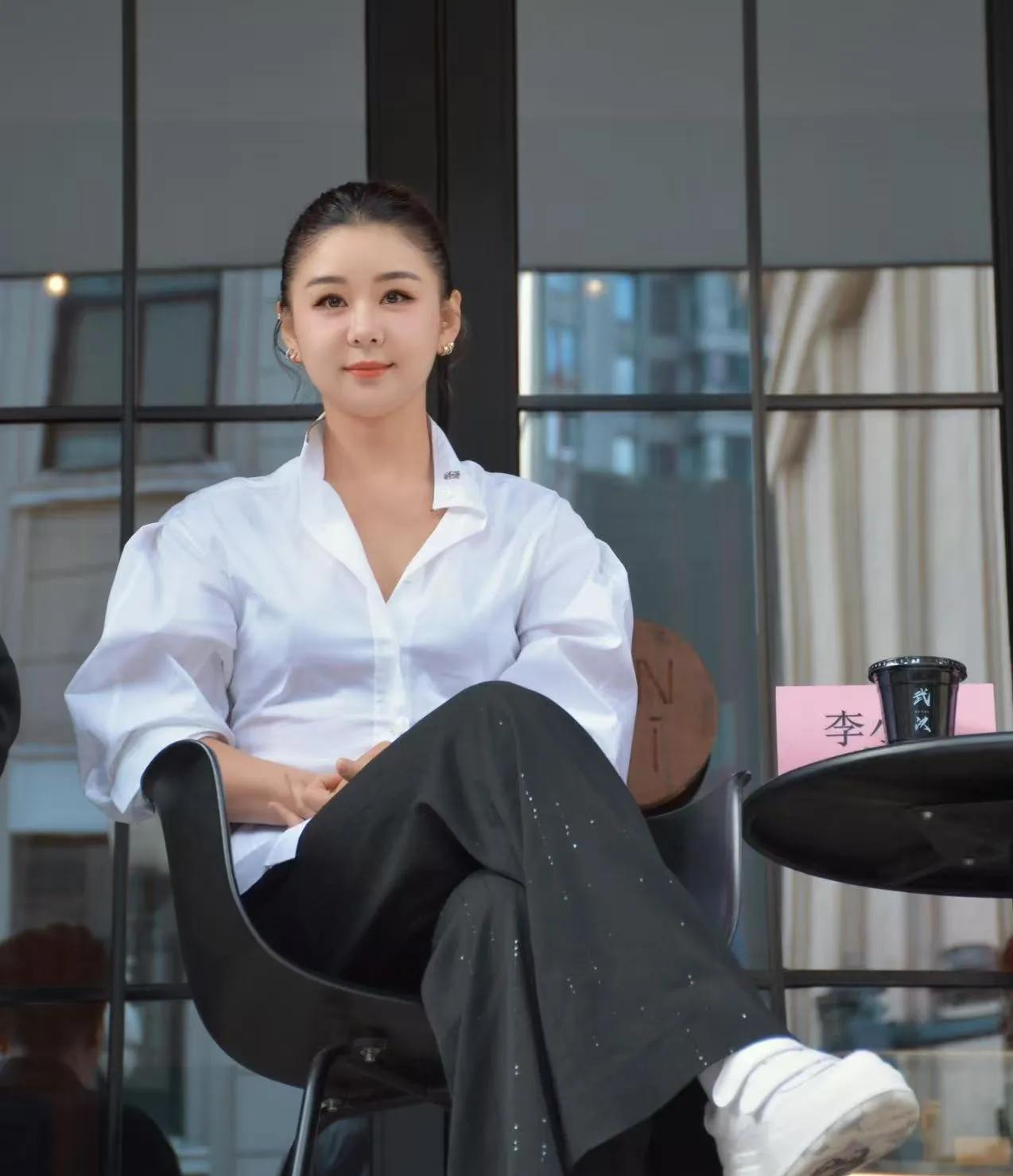 李小萌穿搭教科书白衬衫搭配带细闪装饰的黑色阔腿裤，脚踩小白鞋，基础款穿出拉满高