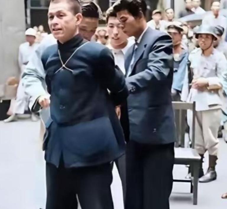 1949年5月11日，上海街头，一个56岁的男人蹲在凳子上写遗书。他穿着整洁的中