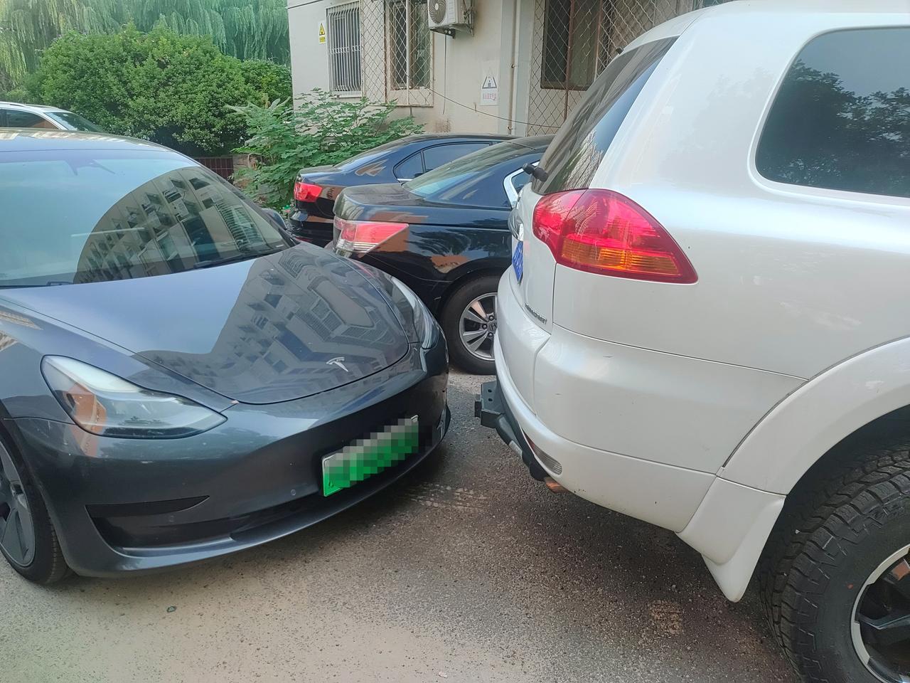 这个白车怎么开出去车前面就是围挡小区里的车停的好乱开车不容易呀