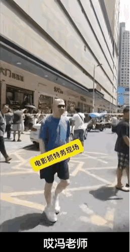 在《抓特务》的拍摄现场，粉丝拿手机拍摄正在迎面过来的导演，一边打招呼：“冯老师冯