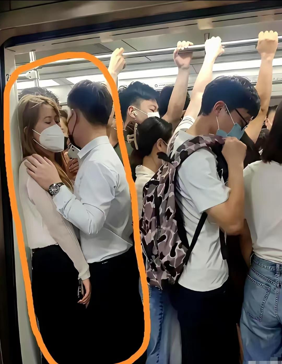 挤得满满当当的车厢里，两人紧紧贴在一起，男生手搭在女生肩上。大家猜猜，他们是情