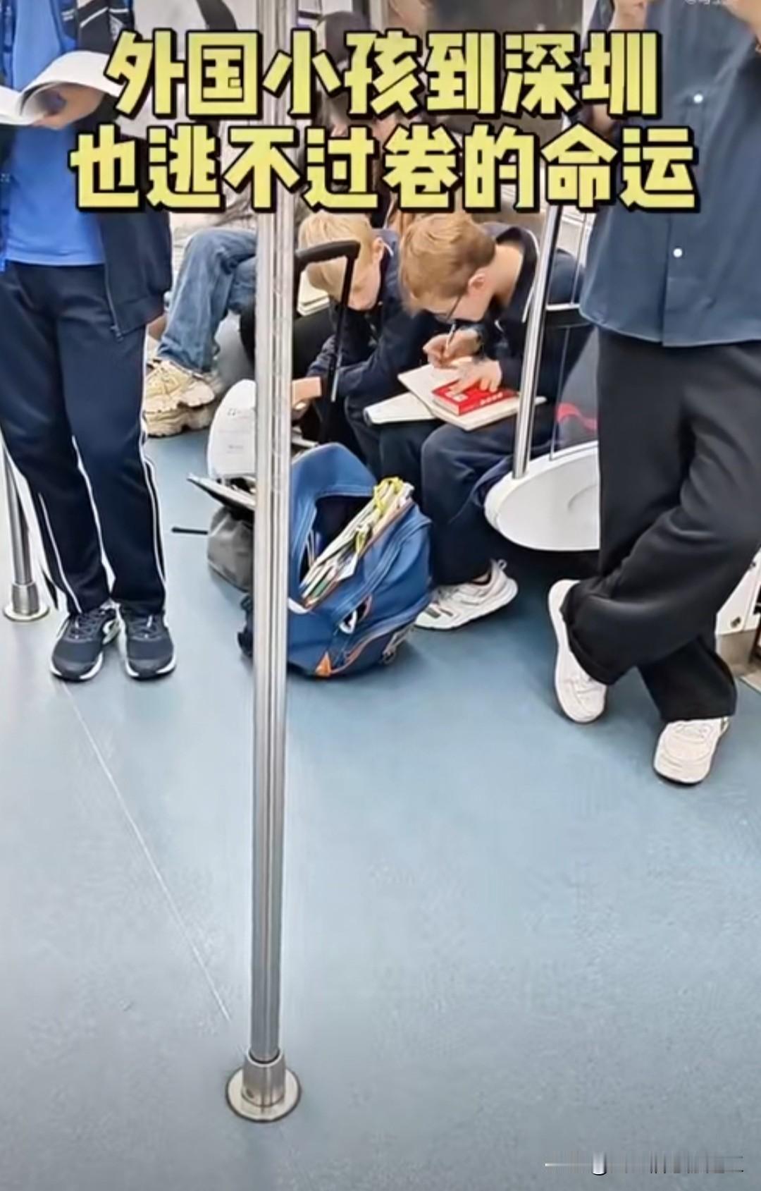 外国小孩在深圳地铁里写作业，一个已经戴上眼镜，也要跟着卷起来