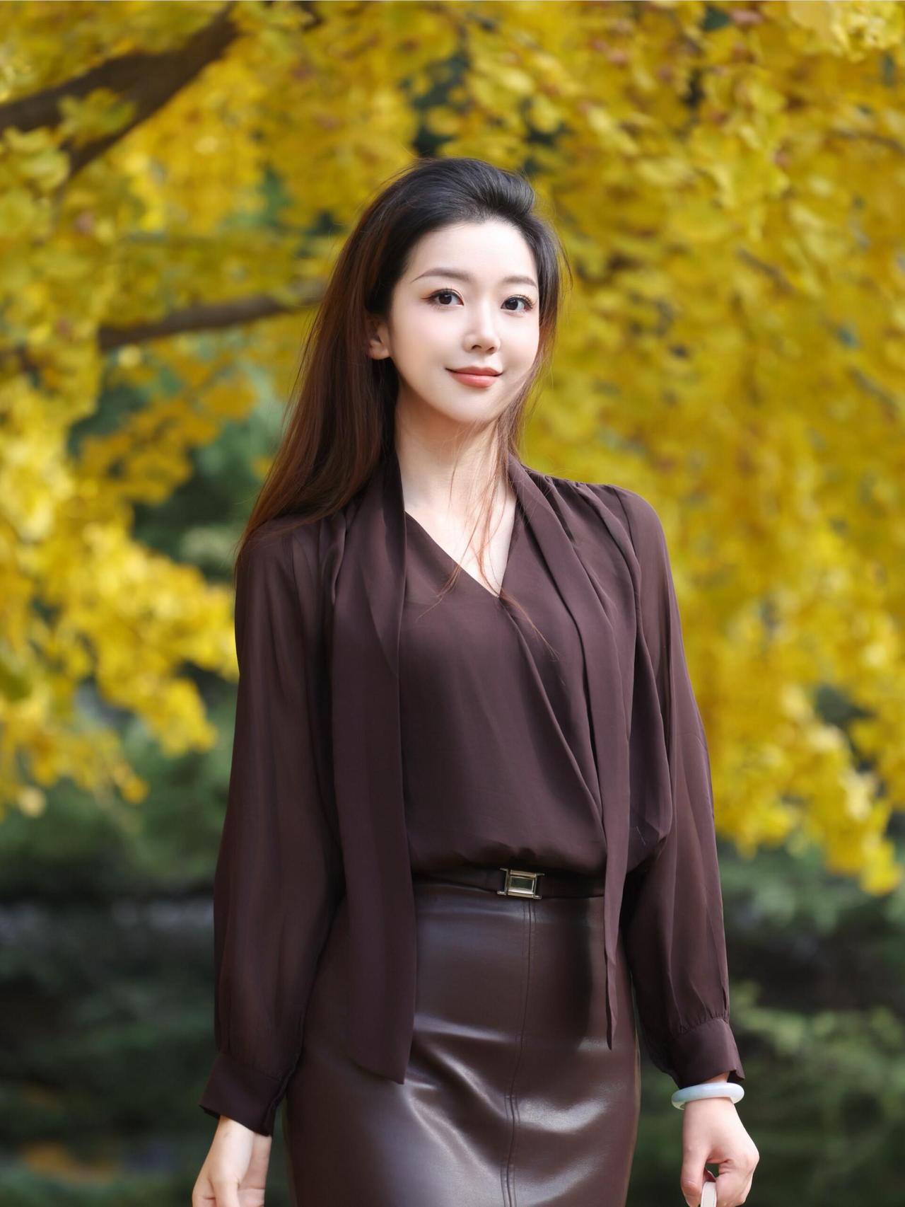 满城尽带黄金甲，风过处，银杏叶簌簌叠成秋的信笺。她立在金箔般的光影里，茶棕