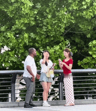 街头拍到两名年轻女子主动邀请一个黑人男子和她们一起合影？搞笑的是那名黑人男子在