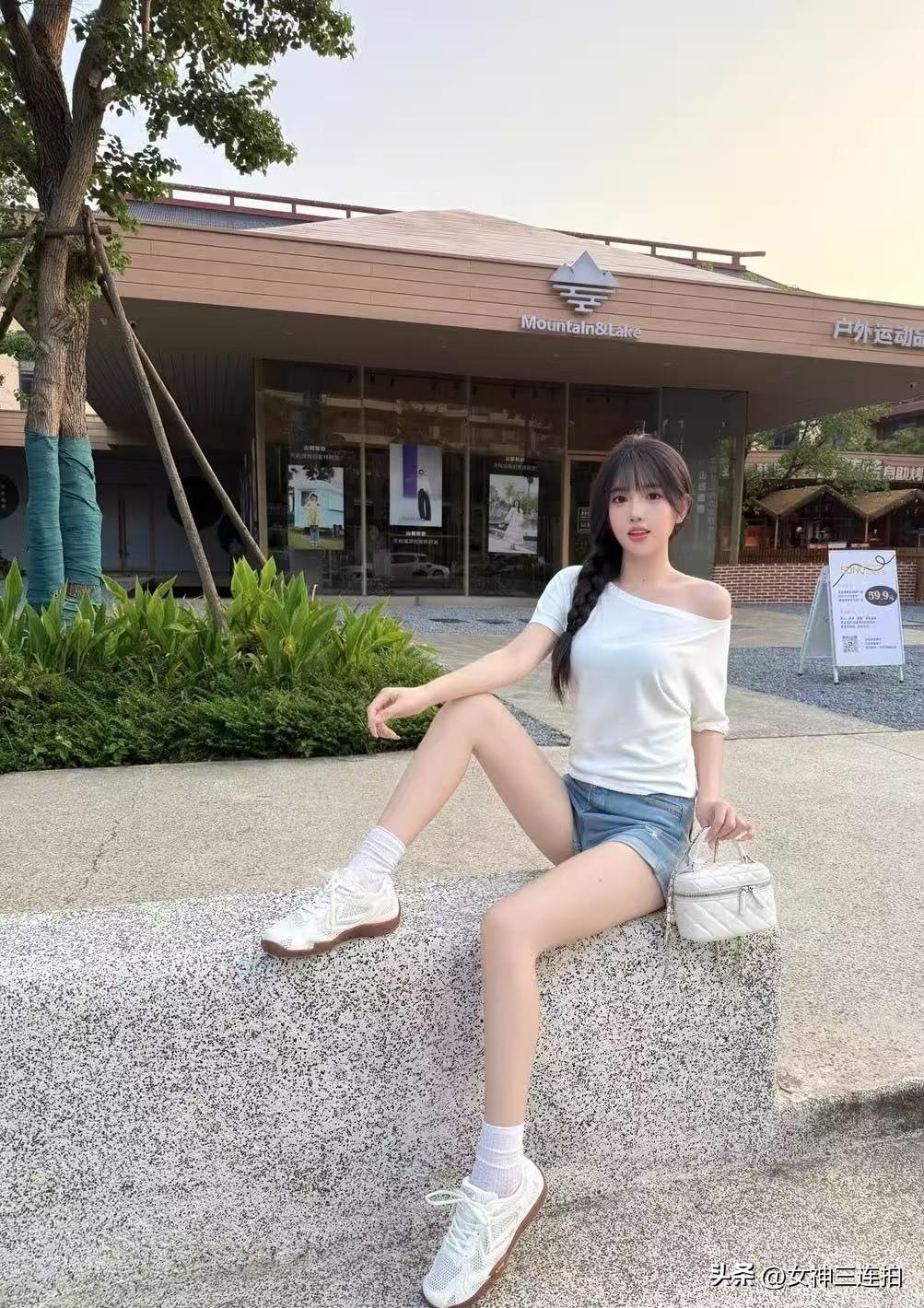 一个女孩坐在台阶上，背景是户外运动店。