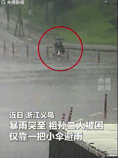 义乌，特大暴雨。路边一老奶奶抱着小孙子蹲在地上，就一把小伞。一辆白车停了