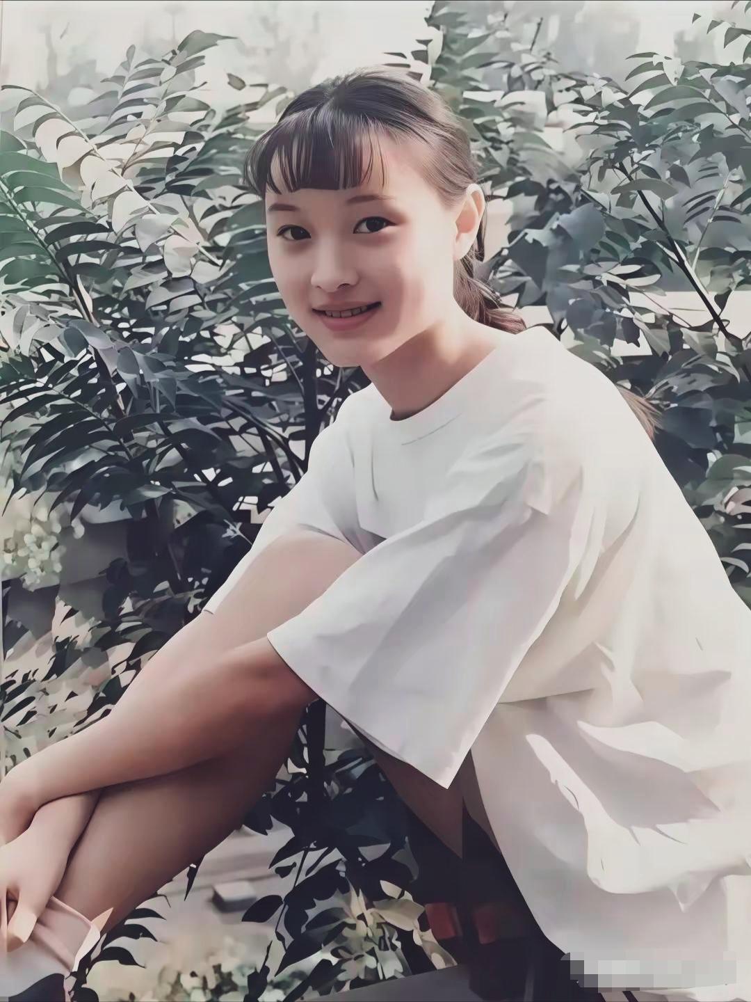 少女吴越，侧身转头看向镜头，齐刘海束起马尾，简单白T衬得一身干净，浅浅一笑，是未