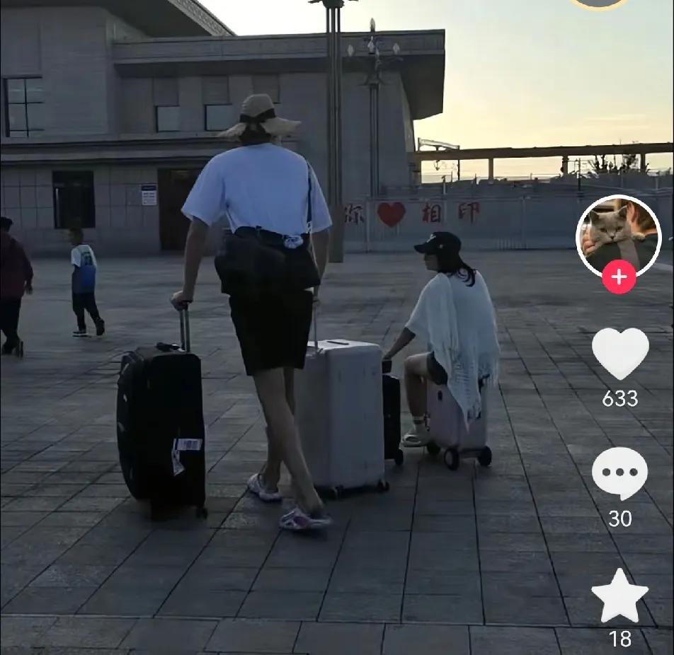杨瀚森和女友在新疆旅游被偶遇非常甜蜜，杨瀚森推着两个大行李箱女友坐在小行李箱上，