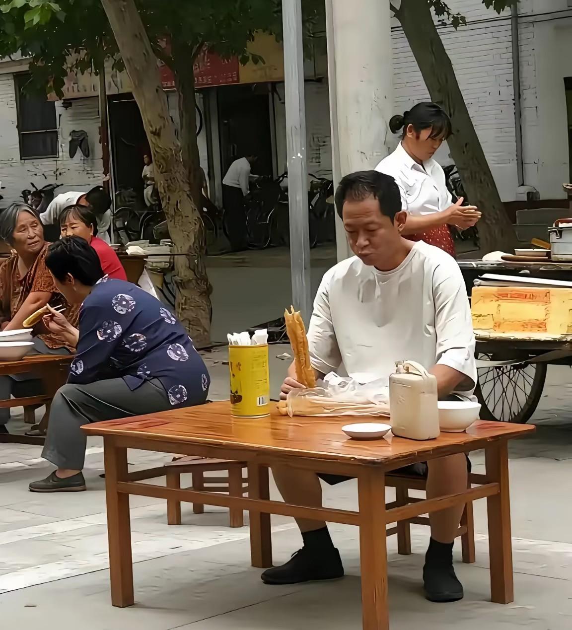 真没有想到，王志文这么接地气，一个大明星，居然在吃路边摊。白色上衣搭配黑色短