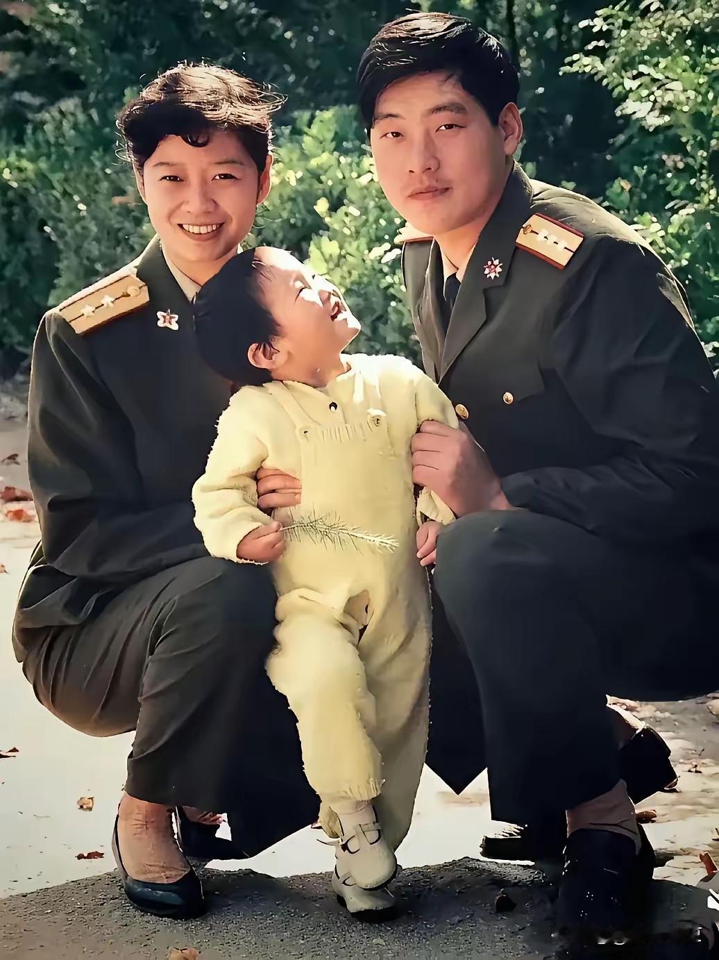 这是常晓军和南冬冬身着军装，与小孩的合影照。女人是专业技术中尉，男人是济南军区