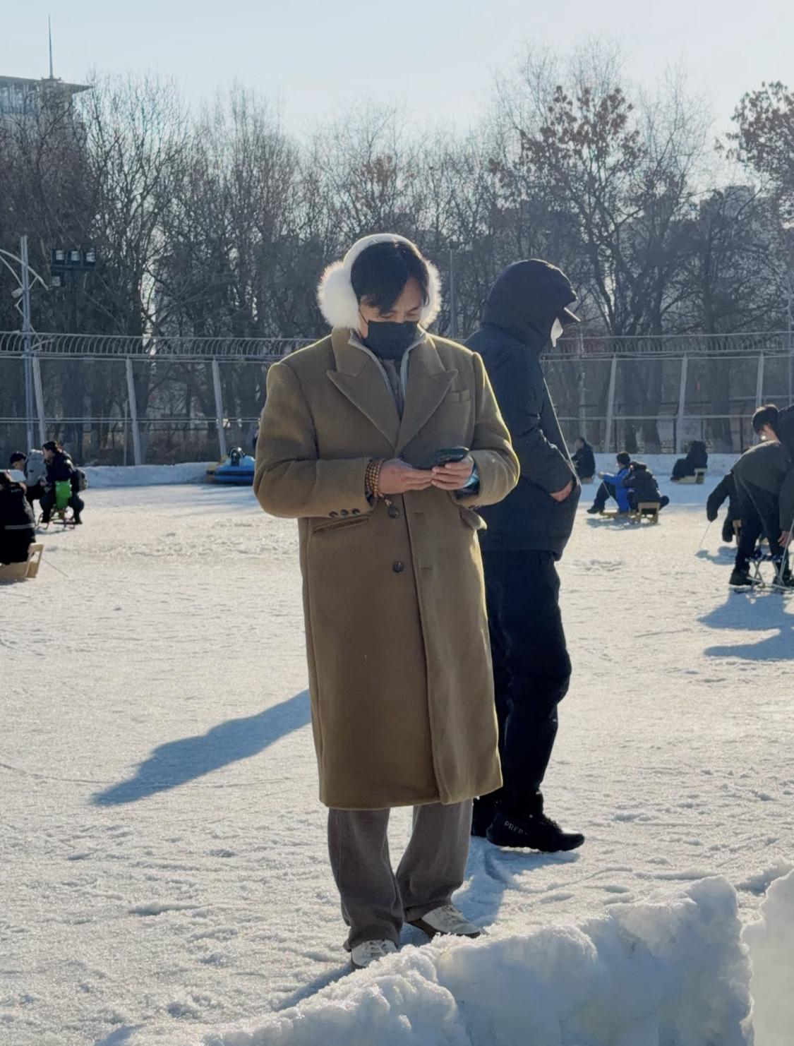 秦昊过年回老家沈阳，带孩子玩冰车。钢铁直男带着白色耳包很显眼。秦昊还是有点偶