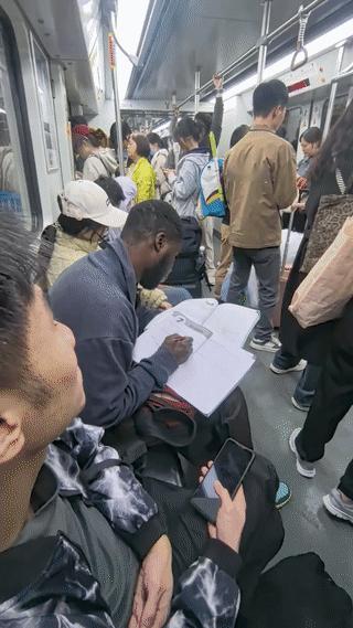 广州地铁上有网友拍到一位正在认真学习的黑人留学生。当时他正坐在地铁椅子上做填空