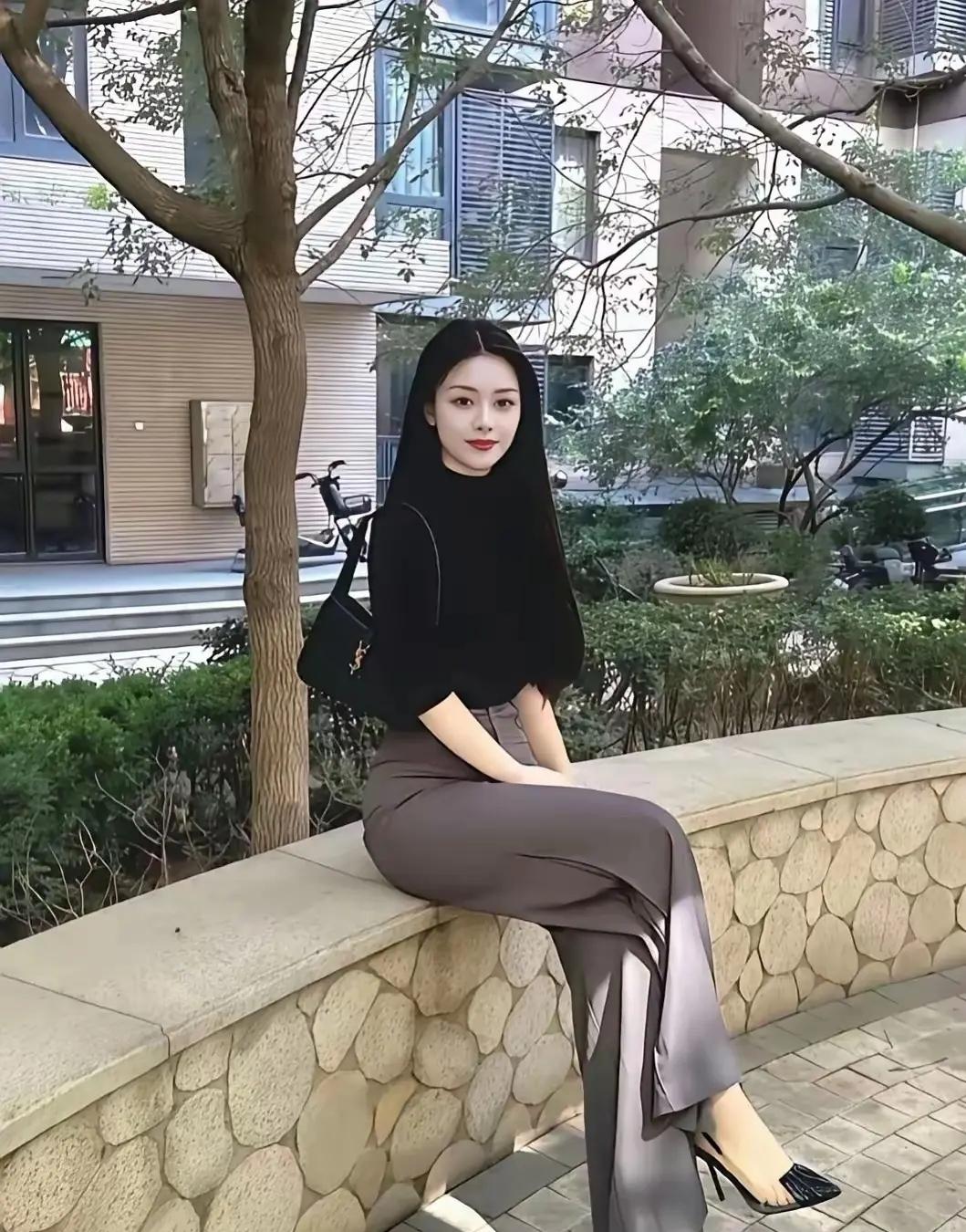 美女坐在石墙上，姿态优雅。