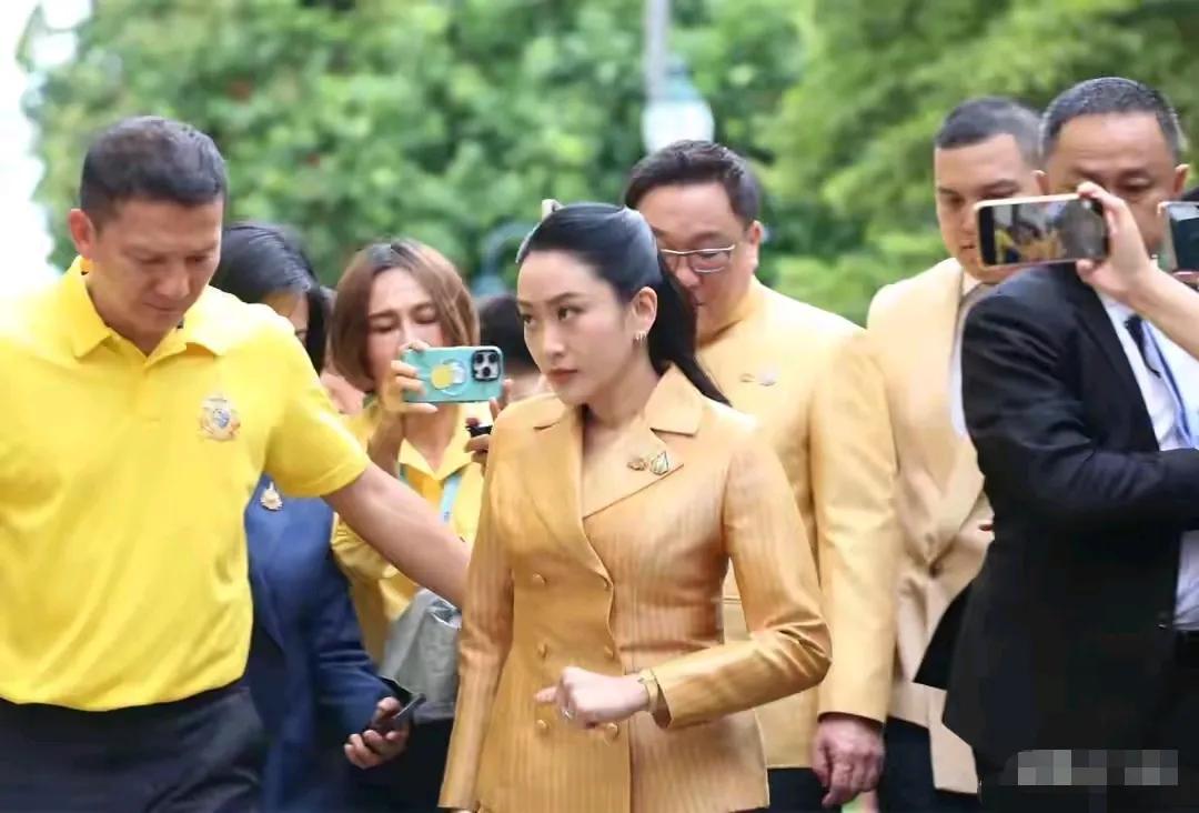 佩通坦面无笑容，脸上甚至还有点愠色但她和身旁的人大多都穿明朗色彩的服装，整张照片