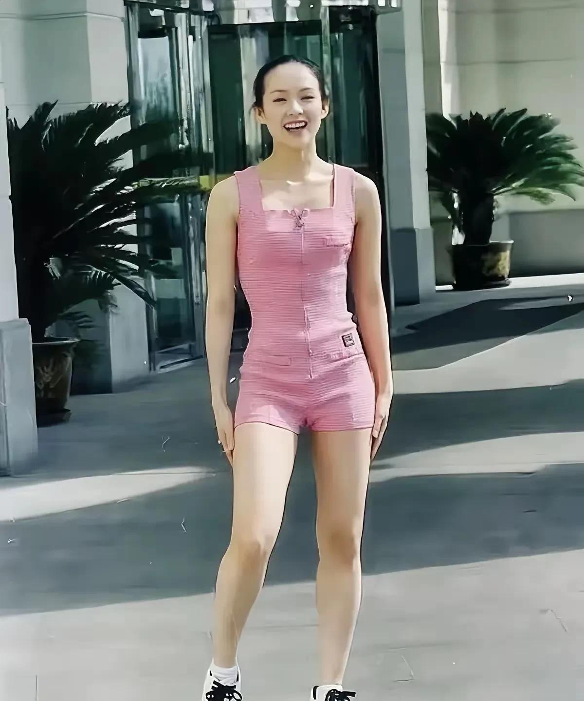 这是章子怡在大学时期的街拍照片，她当时正在中戏上学。照片中的章子怡穿了一件粉色衣
