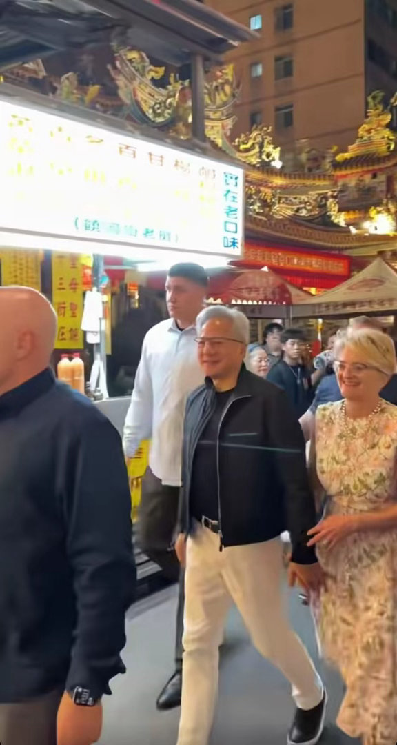 黄仁勋携妻子逛台北夜市时的一幕，妻子一路挽着黄仁勋的手笑靥如花。
