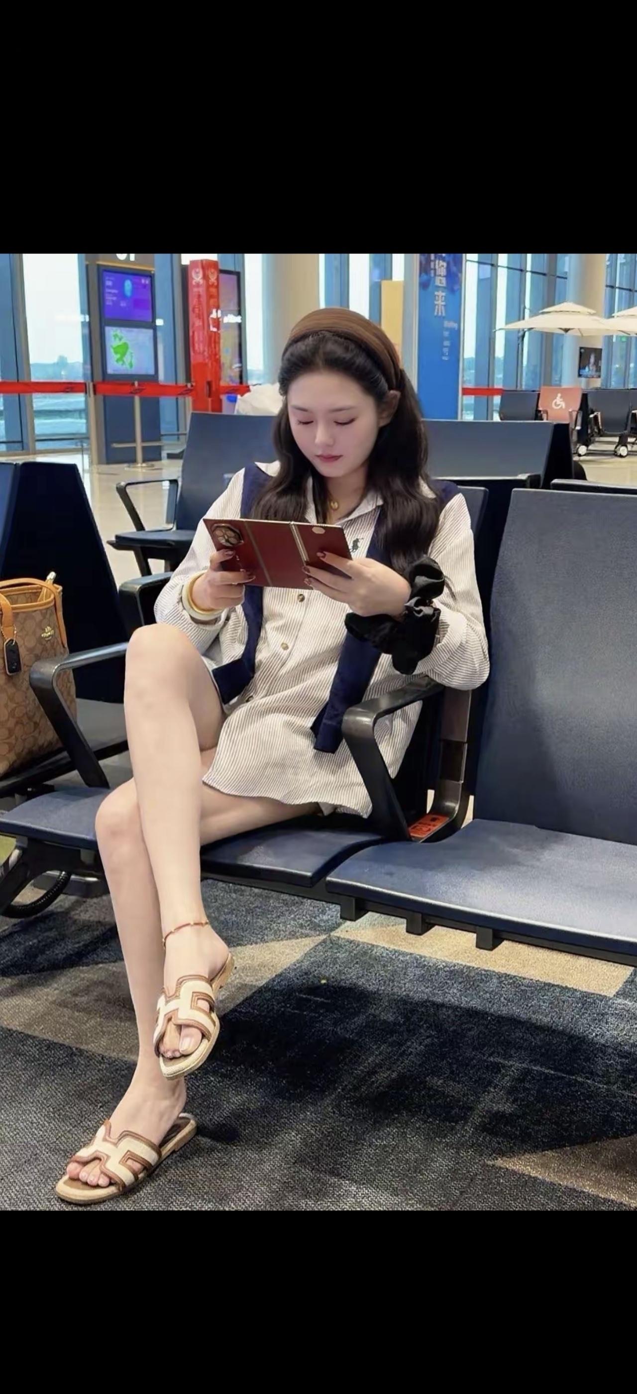 一个女孩在机场看手机。
