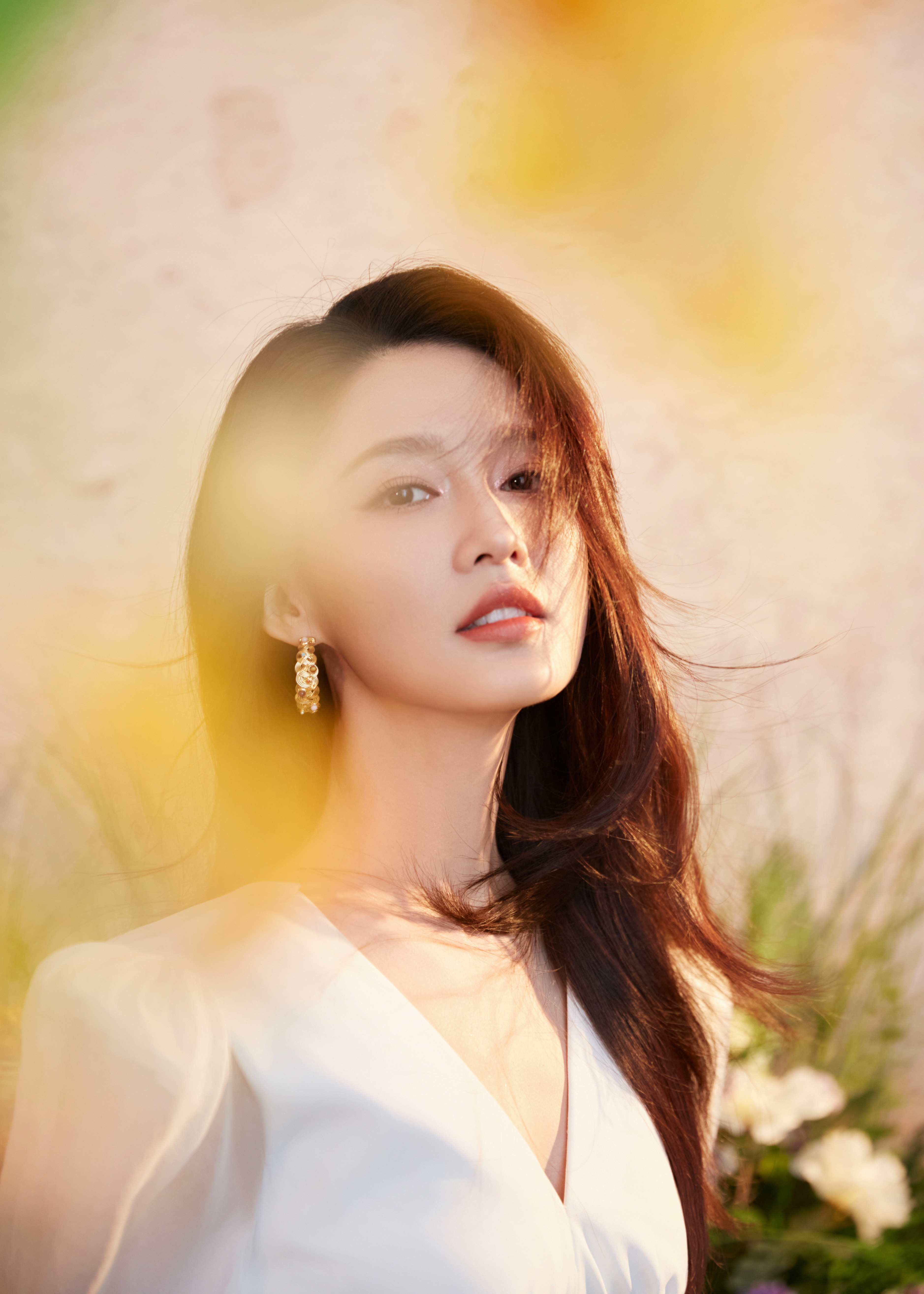 李沁在花簇间浅笑，像把春日的明媚都穿在了身上，每一缕发丝都浸着温柔与烂漫。李