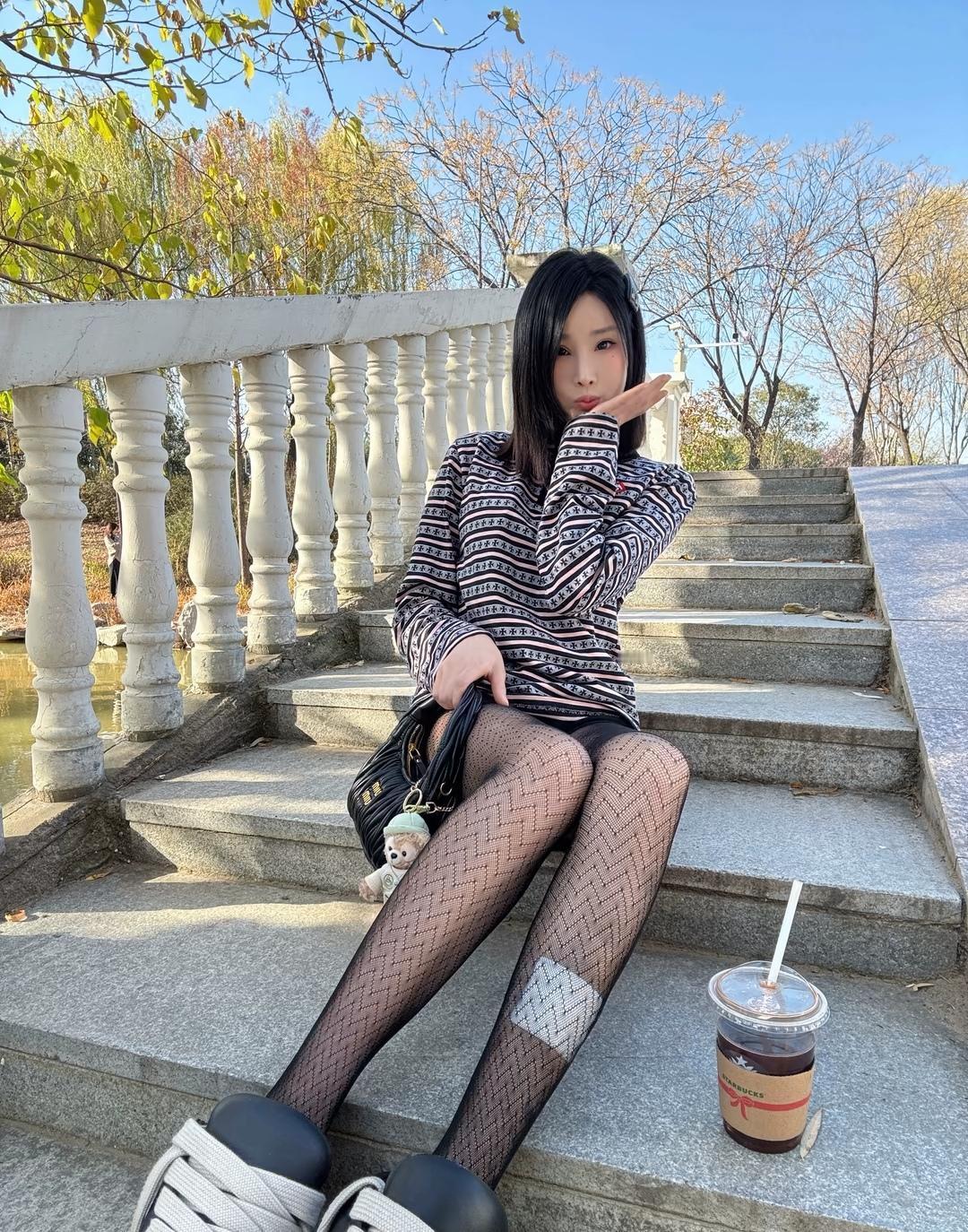 秋日暖阳下，少女轻靠栏杆，享受咖啡时光。