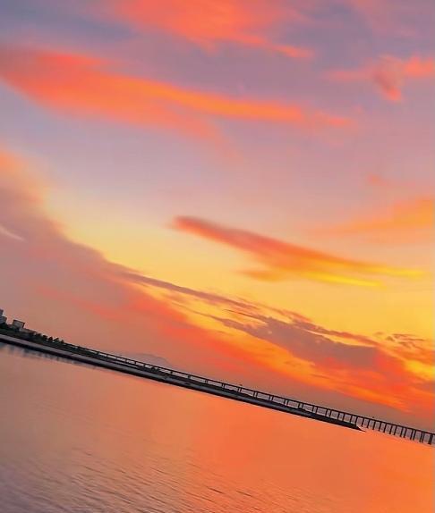 网友拍的胶州湾跨海大桥的醉美晚霞，，落日余晖洒下，那一抹夕阳就像是一幅绝美的画卷