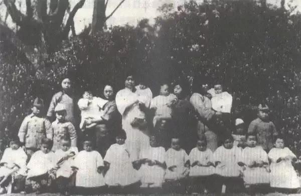 1930年，上海大同幼稚园的老师和孩子们留下了一张合影照片。照片中排：左一为毛