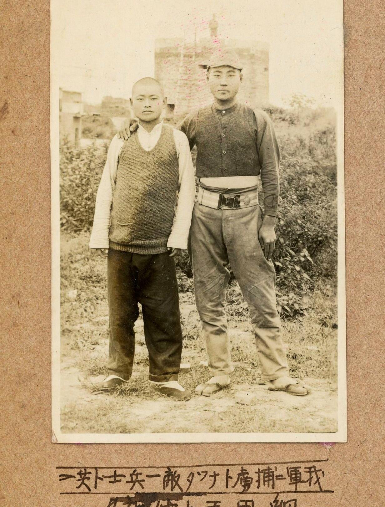 这是在日军相册中发现的一张照片。照片下方用日文写着：“我军捕虏敌军一名士兵”等字