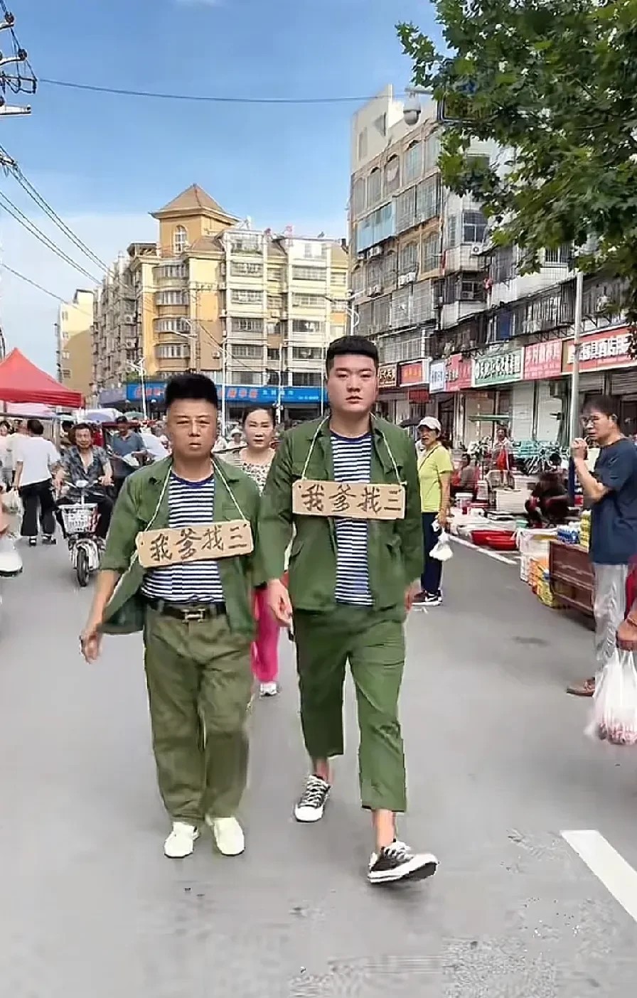 这是真的还是作秀呢？两个男子身上写着，我爹找三的字样，在大街上来回溜达。引起好多
