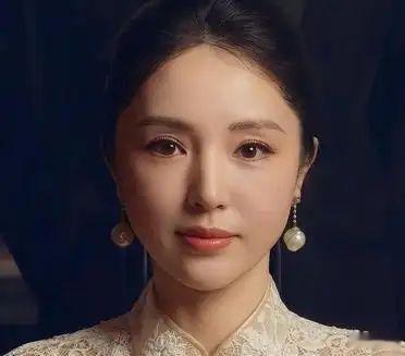 董璇身着蕾丝旗袍，手持团扇温婉一笑，东方韵味与精致妆容交织，尽显优雅迷人。