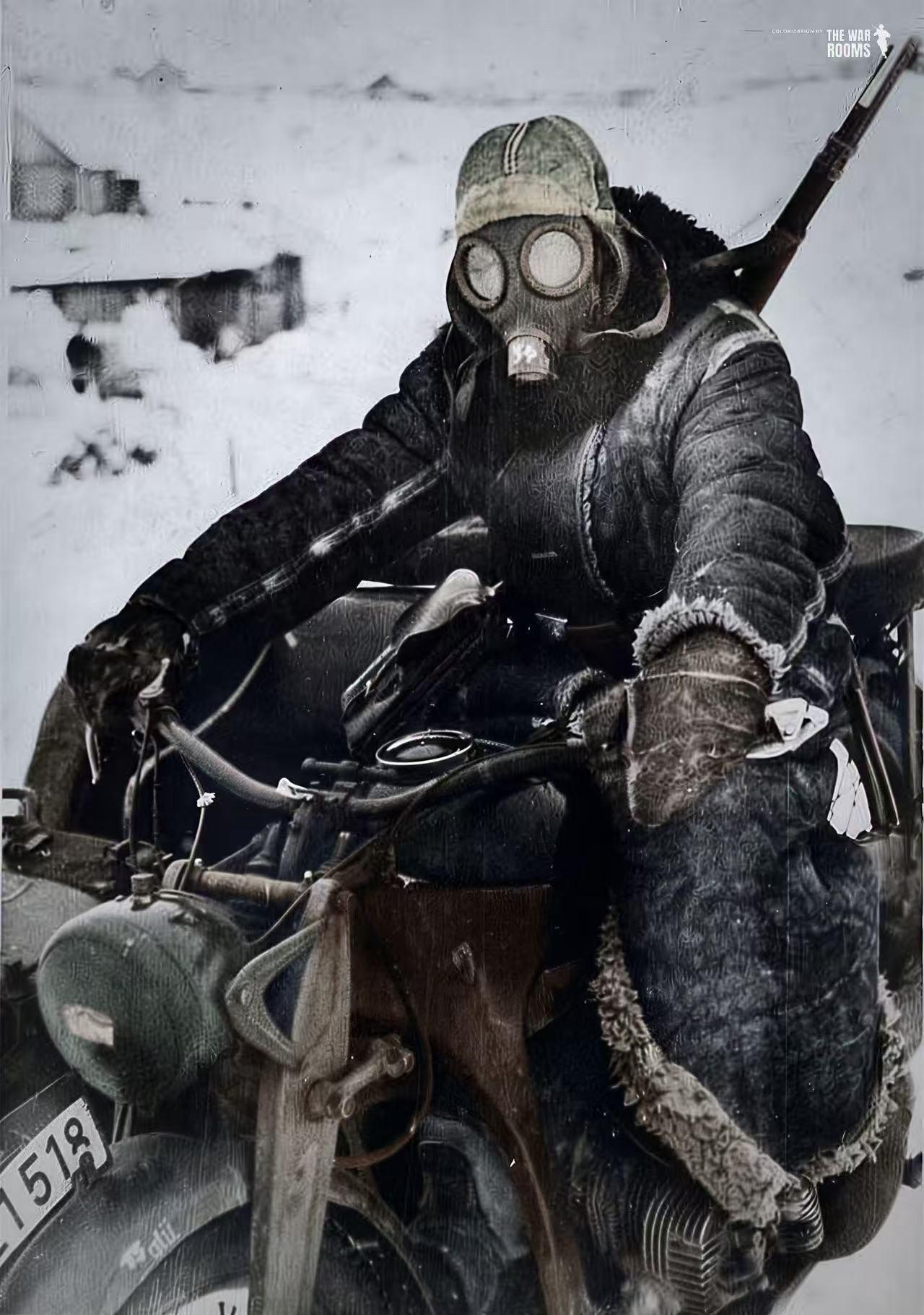 1941年，二战东线冬季战场，一名德军士兵正骑着尊达普军用摩托，佩戴防毒面罩行进