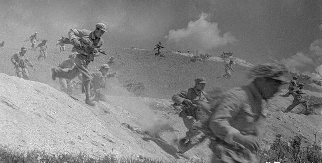 1952年，朝鲜战争结束后，美国军人在整理战场时将志愿军的尸体集中堆放，这一情景