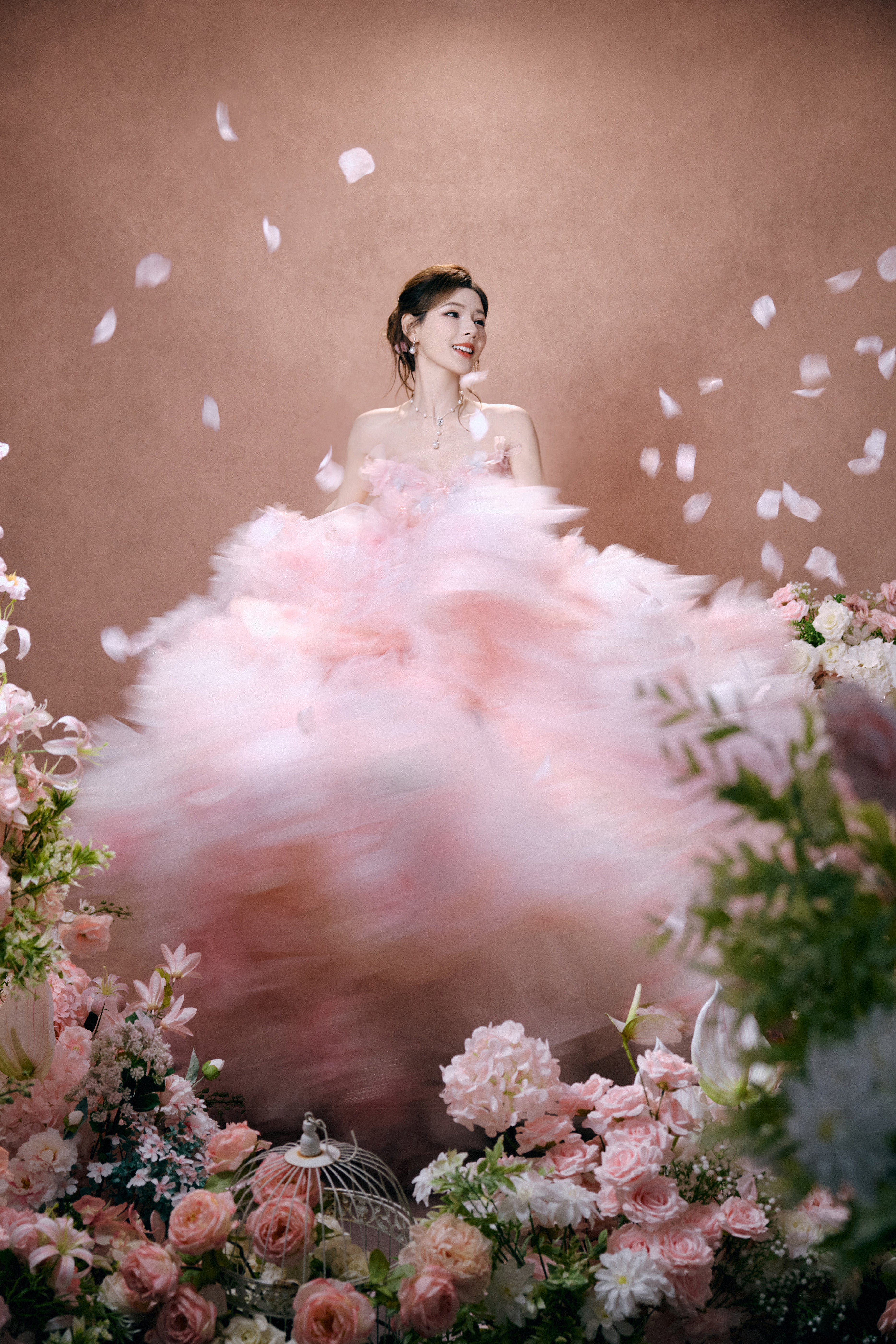 张予曦以繁花为裙，赴一场春日的浪漫之约。粉雾纱裙缀满立体花饰，层叠裙摆如云似雾