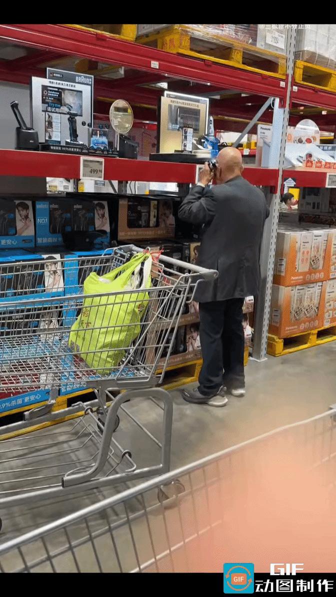 上海，山姆会员商店，一光头老人走到剃须刀展示区，拿起一把电动剃须刀仔细端详。反