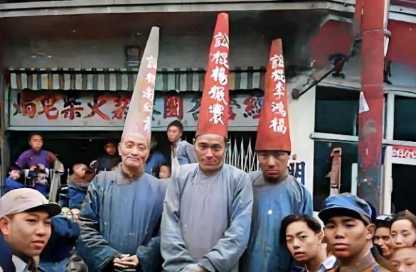 1949年11月，上海街头，杨振寰等三名旧时代“讼棍”被戴纸帽示众。他们身着长衫