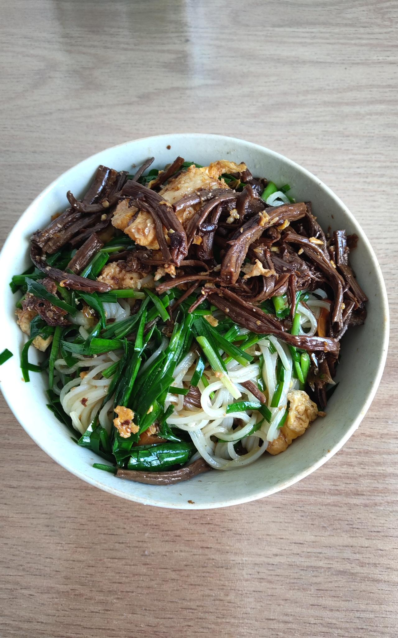 中午又是一顿简单餐食。茶树菇、韭菜、鸭蛋、长条辣椒，与一碗云南米粉拌在一起，营养
