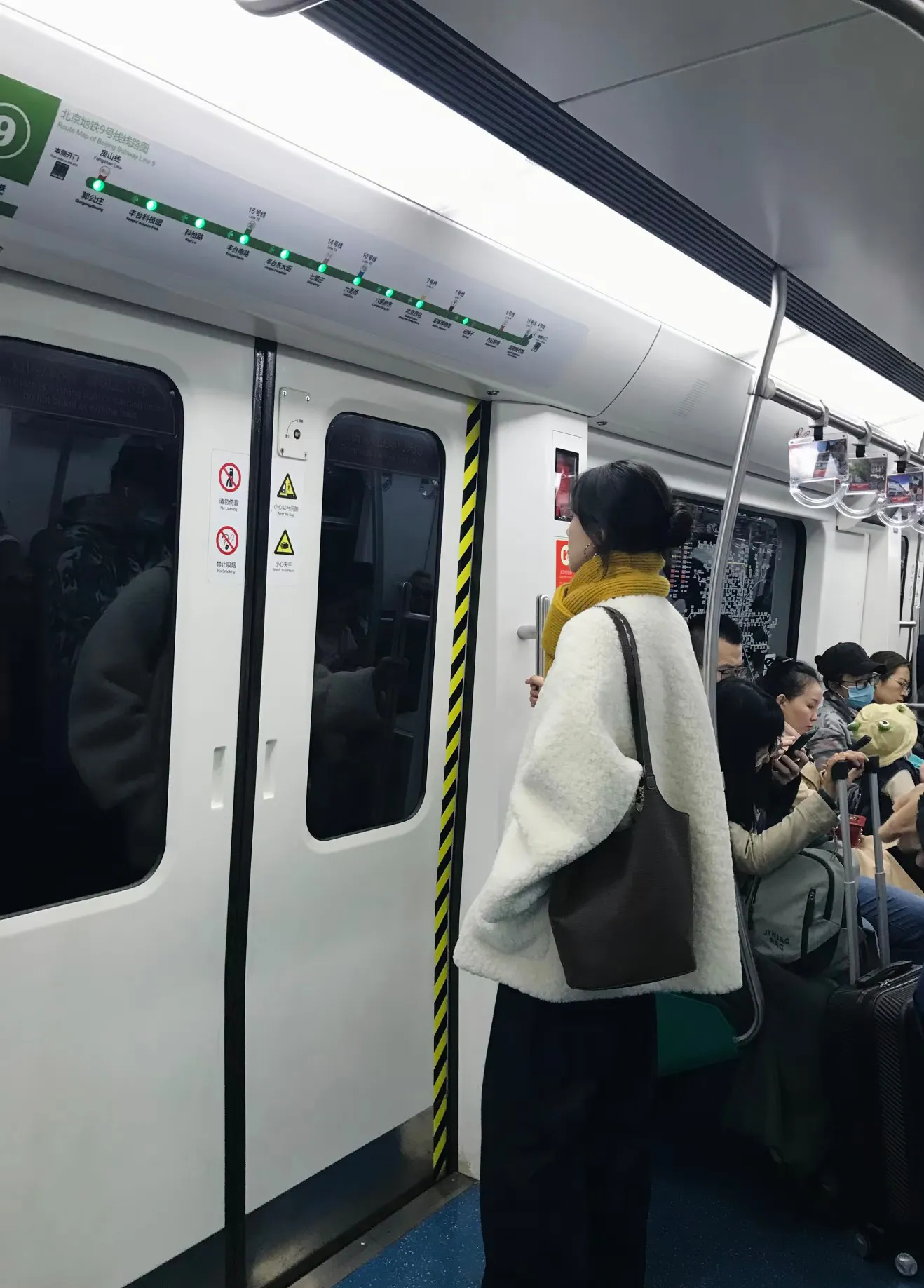 地铁上看到的美女，她真的太好看了吧，穿着白色抓绒衣，带着黄色的围巾，背...