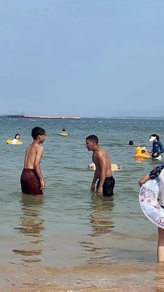 山东烟台一个海滩边上。有网友拍到两个外国男子站在海水里嬉笑打闹。这两个人皮肤
