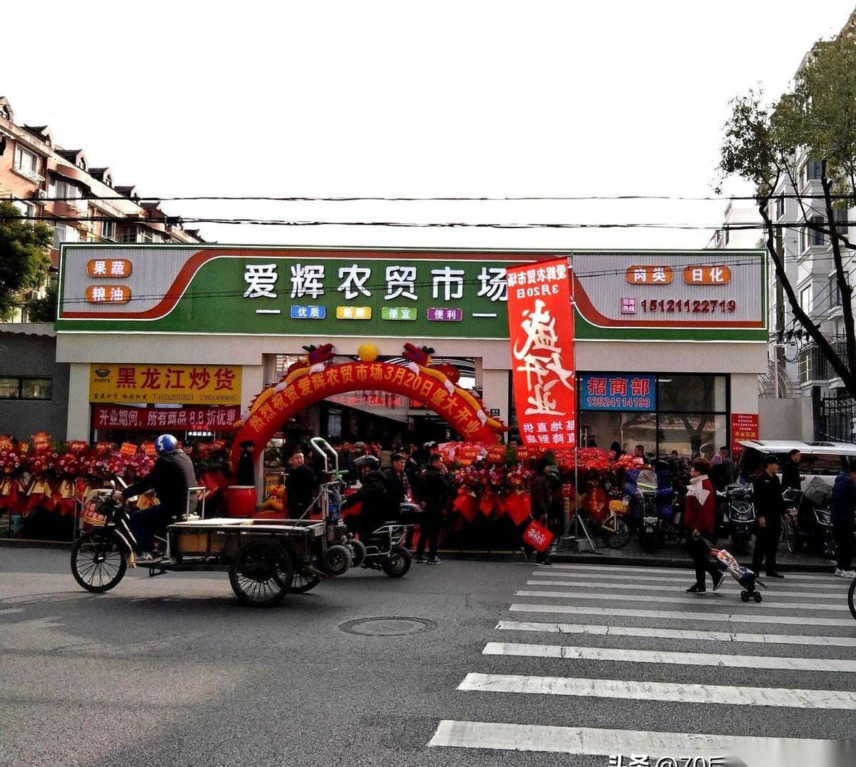 刚拐到宝山爱辉路，人就走不动了。黑压压一片，全堵在那个新刷了漆的农贸市场门口，