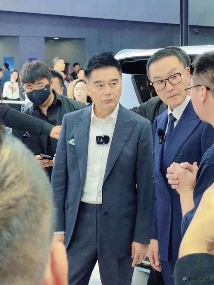 62岁吴刚和61岁许亚军在广州车展被偶遇，俩人穿着西装，气质出众，非常的帅气！[