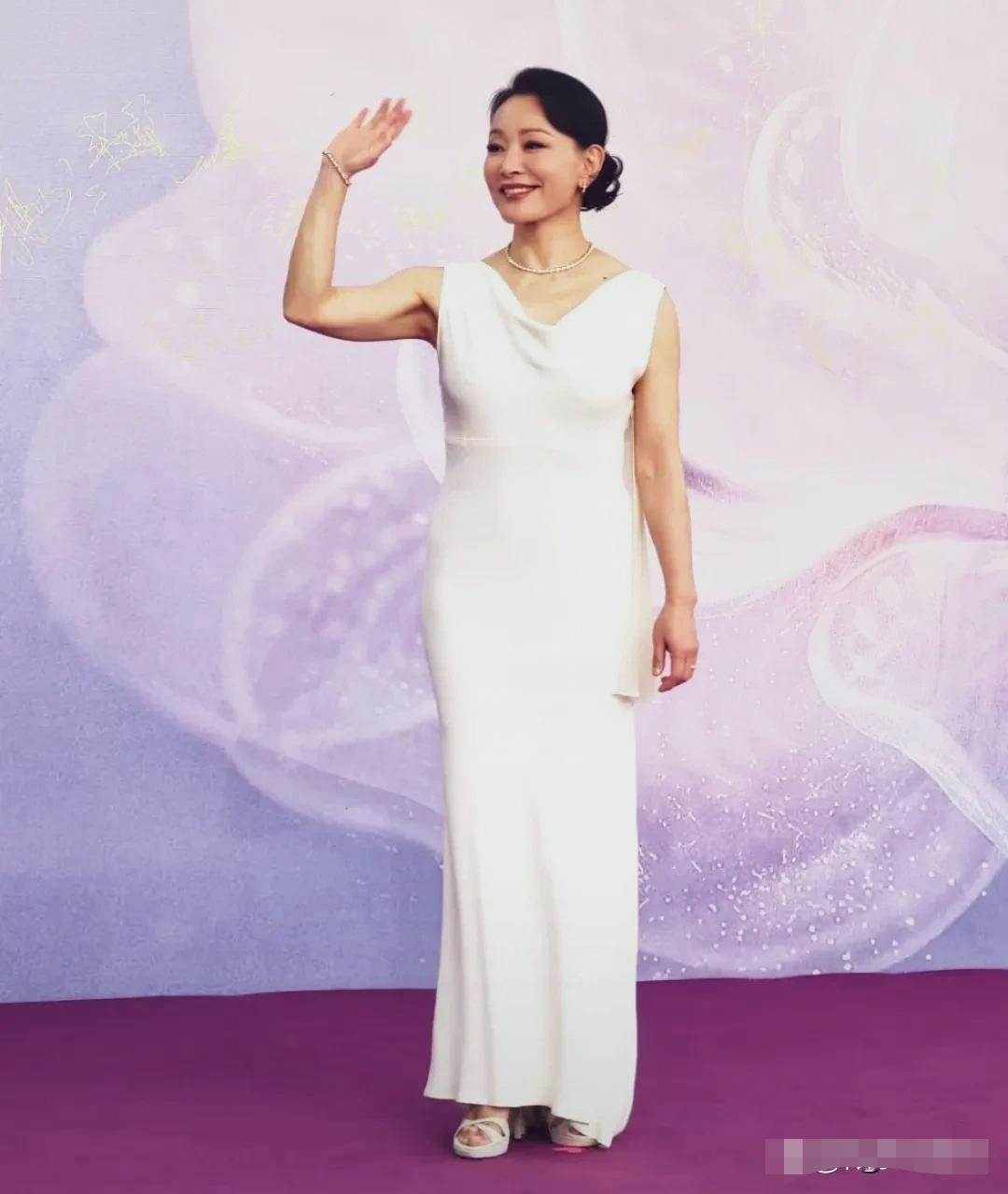 陈冲亮相百花奖红毯一身无袖白色鱼尾长款礼服，黑发盘成低发髻，干净利落。行走红毯