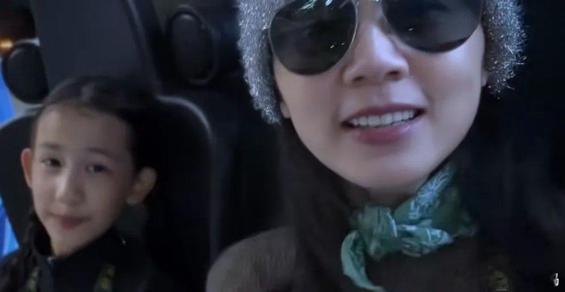 孙莉带11岁二女儿去游乐园，黄少艾坐着吃烤肠，晃眼一看还以为是黄磊梳两条辫子，父