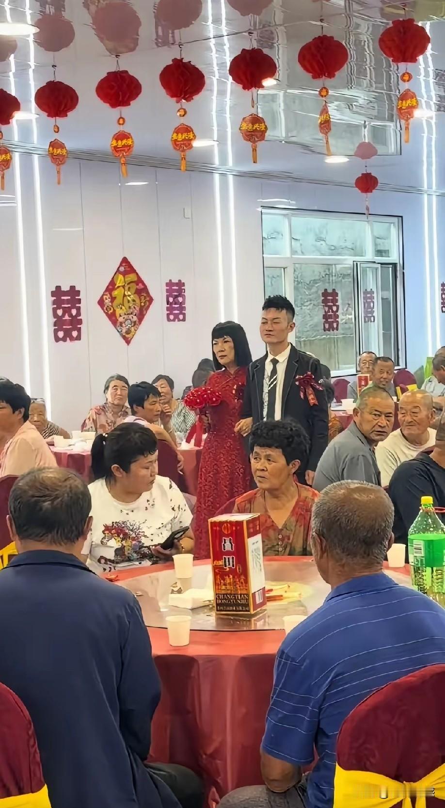 这都是新人的年龄差距是显而易见的，尽管男子的岁数也不小了，但是在这个女人面前，他
